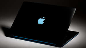 工作室燈光下帶有發光藍色Apple標誌的黑色手提電腦