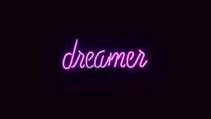 粉紅色霓虹燈牌，上面寫著 dreamer，背景是黑色牆壁。