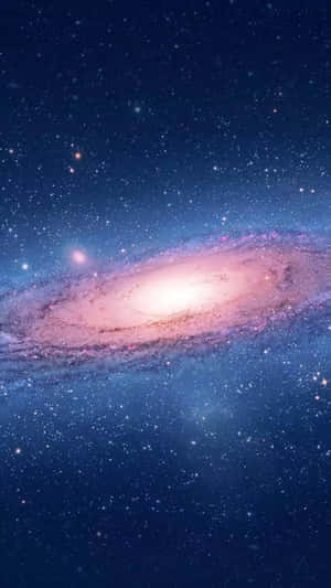 一個在深空中被星星環繞、帶有粉紅色和藍色色調的螺旋星系。 — 粉紅 壁紙