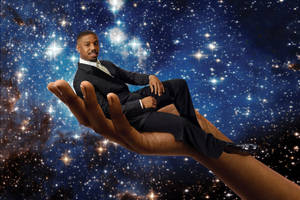 西裝男在星空宇宙背景的巨手上休息 — 可愛星系 壁紙