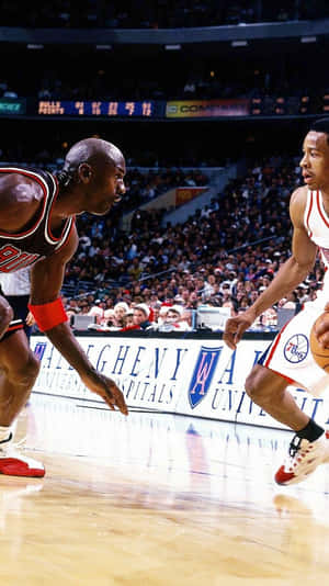 米高佐敦在NBA比賽中，在歡呼的人群面前防守一名籃球運動員。 — Jordan 標誌 GIF 壁紙