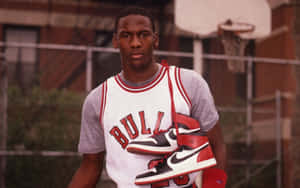 米高佐敦在籃球場上拿著Air Jordan 1運動鞋。 — Jordan 標誌 GIF 壁紙