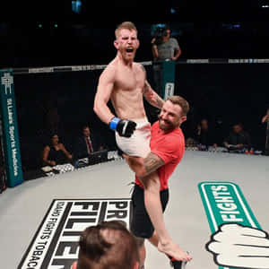 MMA拳手在八角籠內被教練舉起（勝利後）
