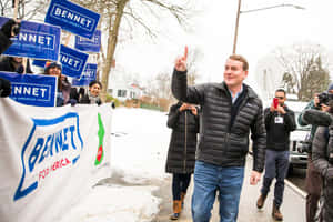 候選人Bennet在積雪的競選活動中向支持者揮手。