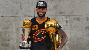 勒邦占士身穿黑色球衣，手持兩個NBA冠軍獎盃。 — 熱力 壁紙