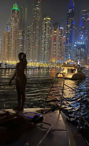 遊艇上的人欣賞夜晚燈火輝煌的杜拜天際線