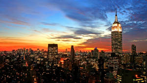 帝國大廈在黃昏時分色彩繽紛的天空下亮起。 — 城市景觀 壁紙