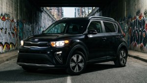 黑色Kia Soul SUV在佈滿塗鴉的城市隧道中行駛。