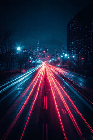 夜間濕漉漉的城市高速公路上，汽車的紅色和藍色光軌，遠處有發光的天際線。 — iPhone 4 壁紙