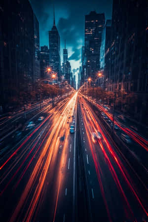 夜晚繁忙城市街道的鳥瞰圖，車燈在高樓之間形成條紋。 — iPhone 4 壁紙