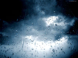 窗戶上的雨滴顯示多雲的天空