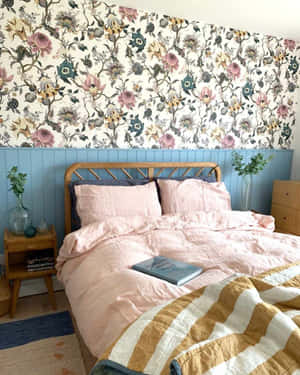 舒適的臥室，配有花卉壁紙、粉紅色床上用品和木製家具。