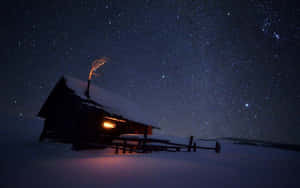 雪中小屋在冬夜星空下散發溫暖光芒。