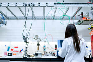 身穿實驗袍的科學家正在使用實驗室設備和電腦工作