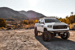 白色升高豐田 Tacoma 停泊喺沙漠，後面有山 — 汽車 壁紙