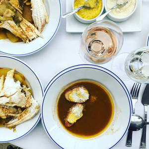 擺有魚、湯和酒的餐桌，營造精緻用餐體驗。