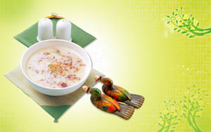 奶油狀的花卉米粥配芝麻和木鴨公仔，綠色圖案背景。 — 中文 壁紙