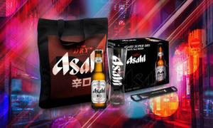 Asahi 啤酒套裝，包括玻璃杯和手提袋，以發光的霓虹城市背景為襯托。 — 日本 壁紙