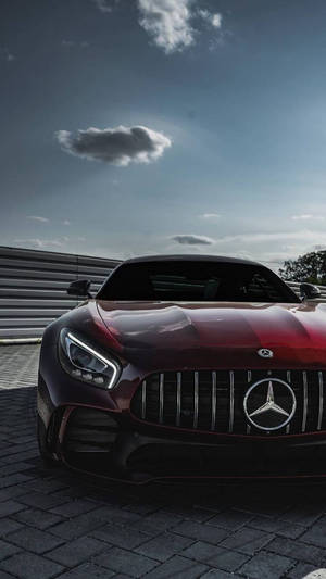 紅色Mercedes-AMG GT跑車停泊在賽道護欄附近的鵝卵石上。