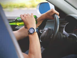 駕駛汽車的人拿著綠色啤酒瓶戴著手錶