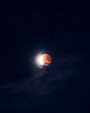 月食期間的紅色月亮，伴隨著星星和雲朵的夜空。