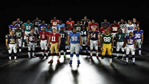 身穿球隊制服嘅NFL美式足球球員喺聚光燈下排成陣型。