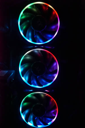 三個RGB電腦機箱風扇在黑暗中發出彩虹光芒。