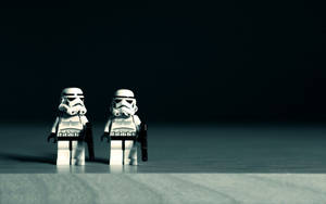 兩個LEGO風暴兵站在反光表面上的昏暗光線中。