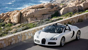 白色Bugatti跑車在海岸懸崖路上，享有海景。