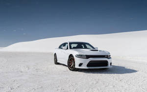 白色 Dodge Charger RT 在白色沙丘上，天空湛藍