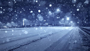 夜晚，雪花飄落在由街燈照亮的黑暗高速公路上。 — 冬天桌面 壁紙