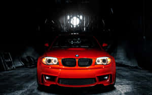 在黑暗的工業車庫中照亮的紅色BMW跑車。