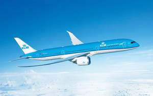 KLM飛機在晴朗藍天的雲層上飛行