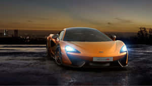 橙色McLaren 570S跑車在暮色中停在潮濕的路面上，背後是城市燈光。