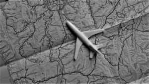 摺疊地形圖上的一個小型白色飛機模型。