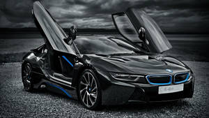 黑色BMW i8，鷗翼車門打開，停在碎石上，背景是風暴天空，帶有藍色點綴。