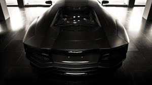 現代陳列室中反射地板上的啞光黑色林寶堅尼Aventador。