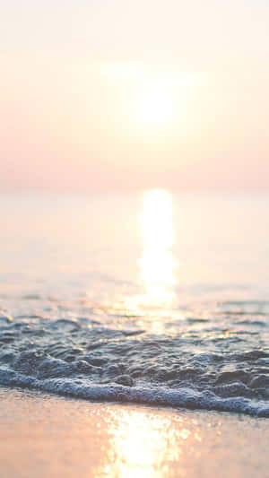 海洋上的夕陽，沙灘上有輕柔的波浪