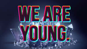 霓虹文字 WE ARE YOUNG 從玻璃晶體中升起，背景深色
