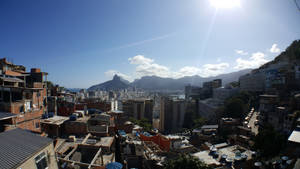 陽光普照的城市景觀，山丘上的紅磚建築俯瞰海灣和群山