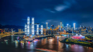 夜間城市天際線，發光的建築物和河上的船隻。 — 唐人街 GIF 壁紙