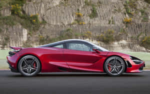 紅色McLaren 720S跑車在賽道上，靠近岩石懸崖。