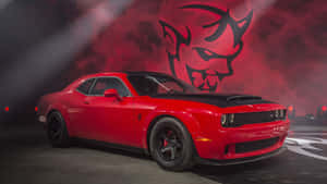 紅色 Dodge Challenger Hellcat，黑色引擎蓋和車輪，在紅色舞台燈光下。