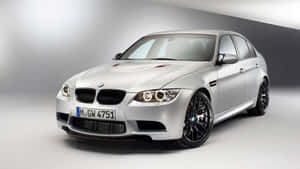 銀色BMW M3運動轎車，配備黑色輪圈和紅色飾條，在攝影棚燈光下。