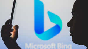 人在 Microsoft Bing 標誌投影前手持電話。