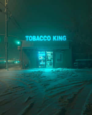 在積雪的冬夜中，Tobacco King 發光的藍色霓虹燈招牌。