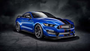 在黑暗的工作室環境中，帶有黑色條紋的藍色Shelby Mustang GT500。