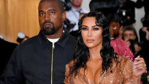 Kanye West 和 Kim Kardashian 在紅地毯活動中，相機閃光燈閃爍。