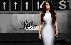 Kim Kardashian 穿著黑白條紋連衣裙站在塗鴉牆前。