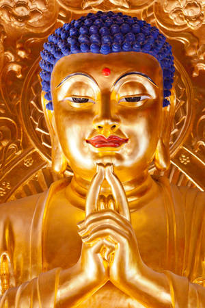 金色佛像，藍色頭髮，雙手合十祈禱姿勢。